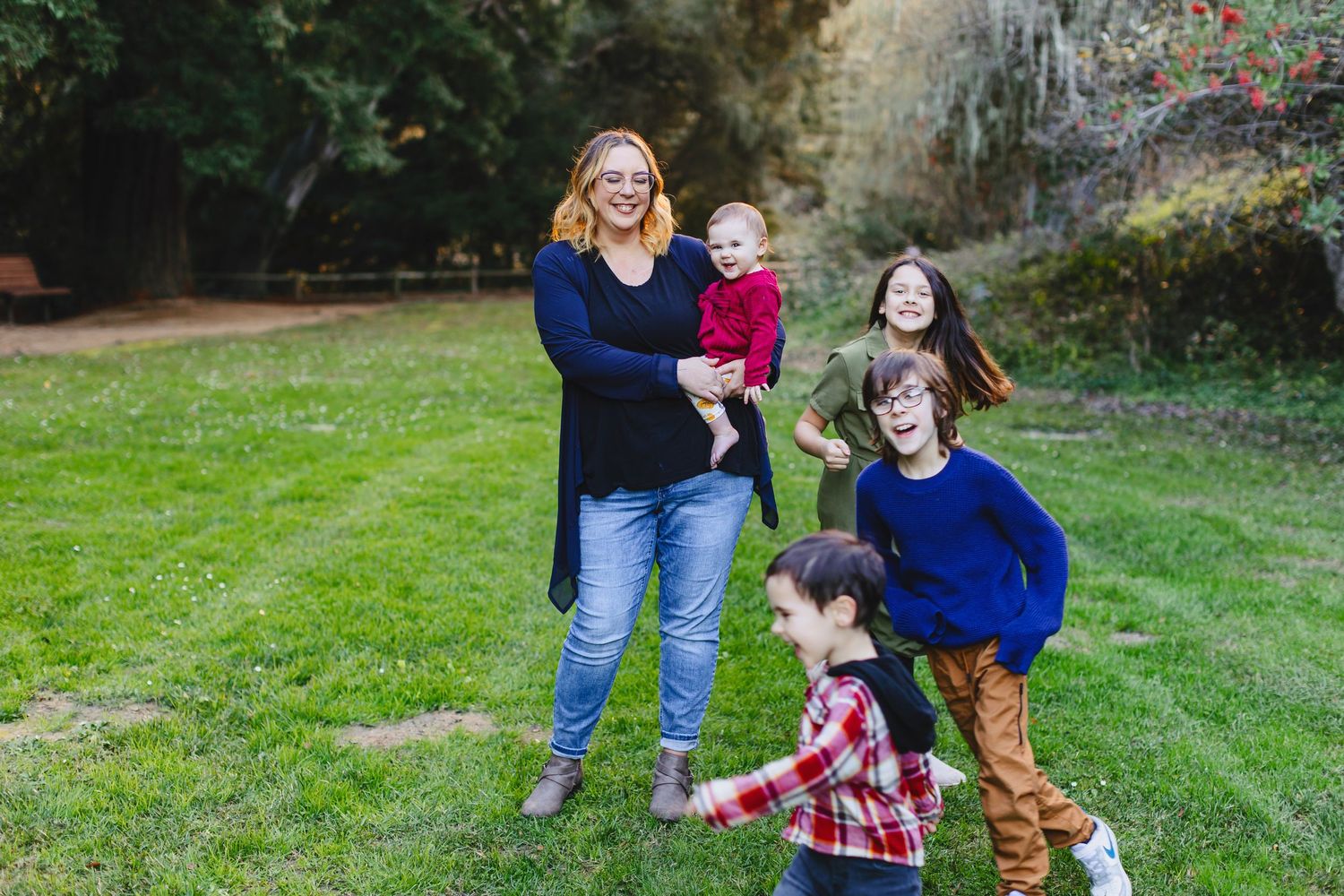 Playful family group enjoying a fun moment together on green grass.