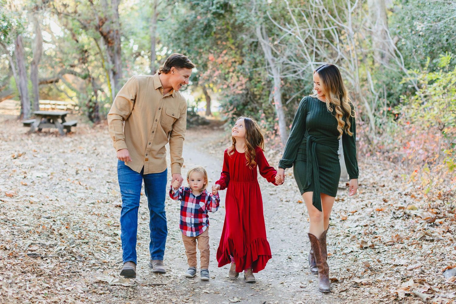 A family walks together on a peaceful forest path during autumn.