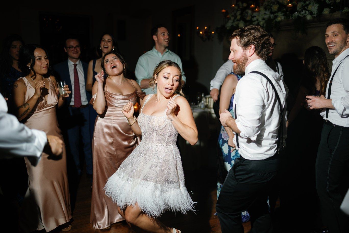 Wedding guests dancing energetically during the reception party.