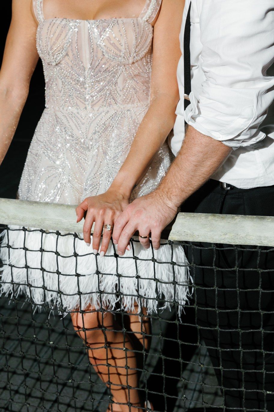 Close-up sequence showing hands adjusting black tennis net against white formal attire and lace detail.