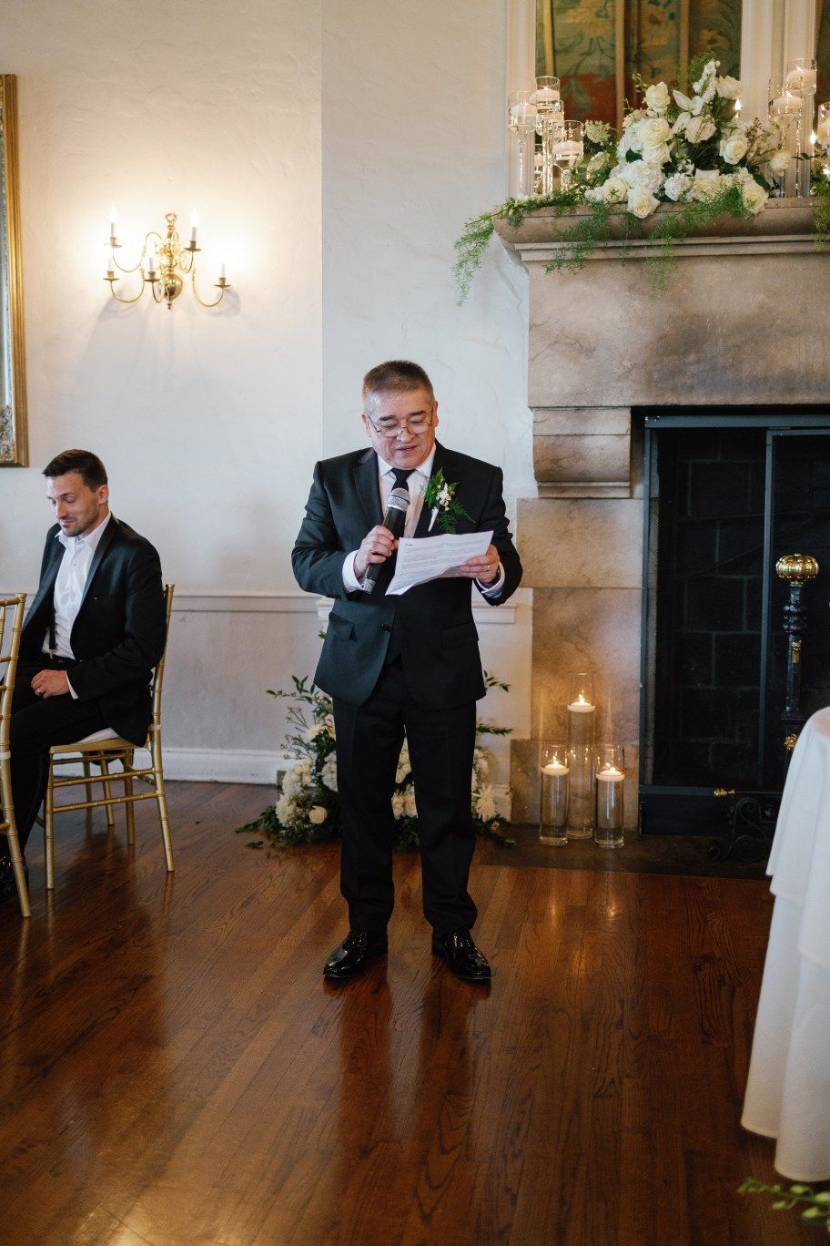 Reception dance floor with white walls, chandeliers and hardwood flooring.