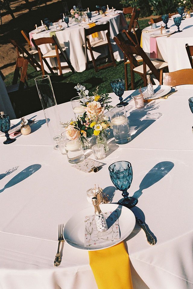 Welcome sign with floral decorations at outdoor wedding.