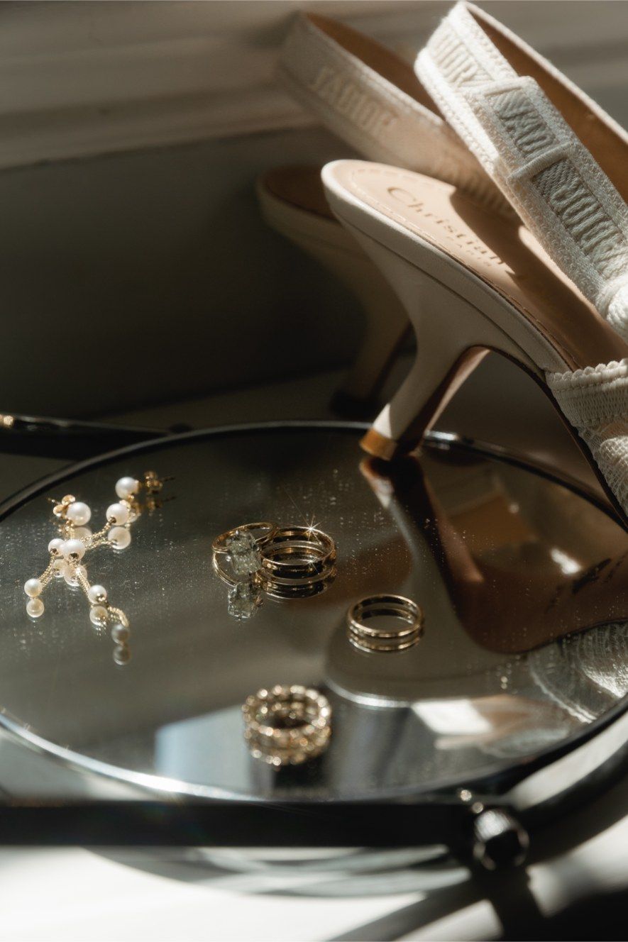 Wedding rings cast reflections and shadows on a shiny black vinyl record surface in dramatic lighting.