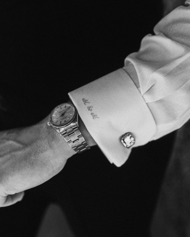 Black and white detail shot of a formal shirt cuff with cufflink and watch.