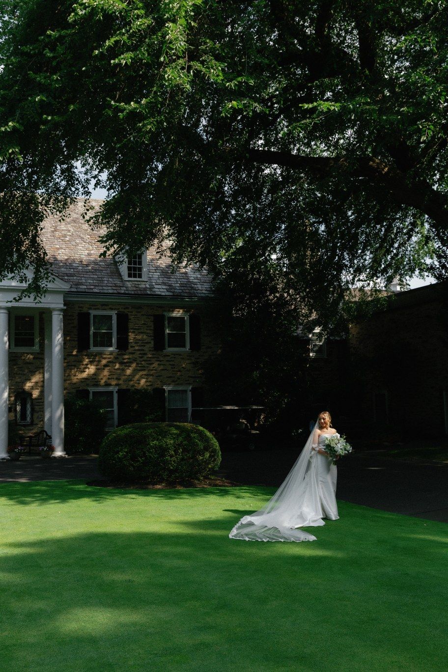 A flowing bridal gown is dramatically captured in a sequence of outdoor photos on a manicured lawn near a historic building.
