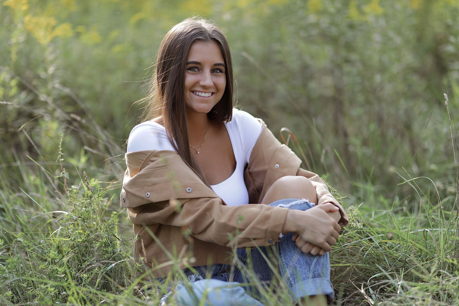 A series of photos showing someone sitting in a grassy field wearing casual clothing and smiling outdoors.