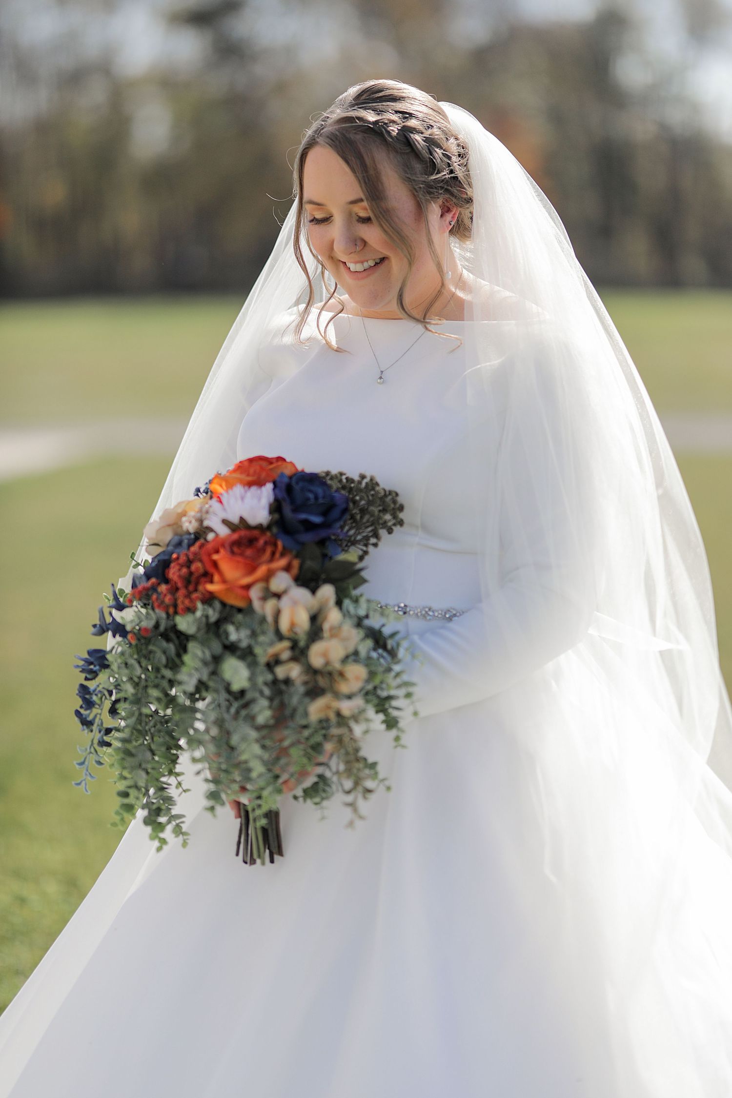 A bouquet of colorful flowers featuring orange and navy blooms with cascading greenery.