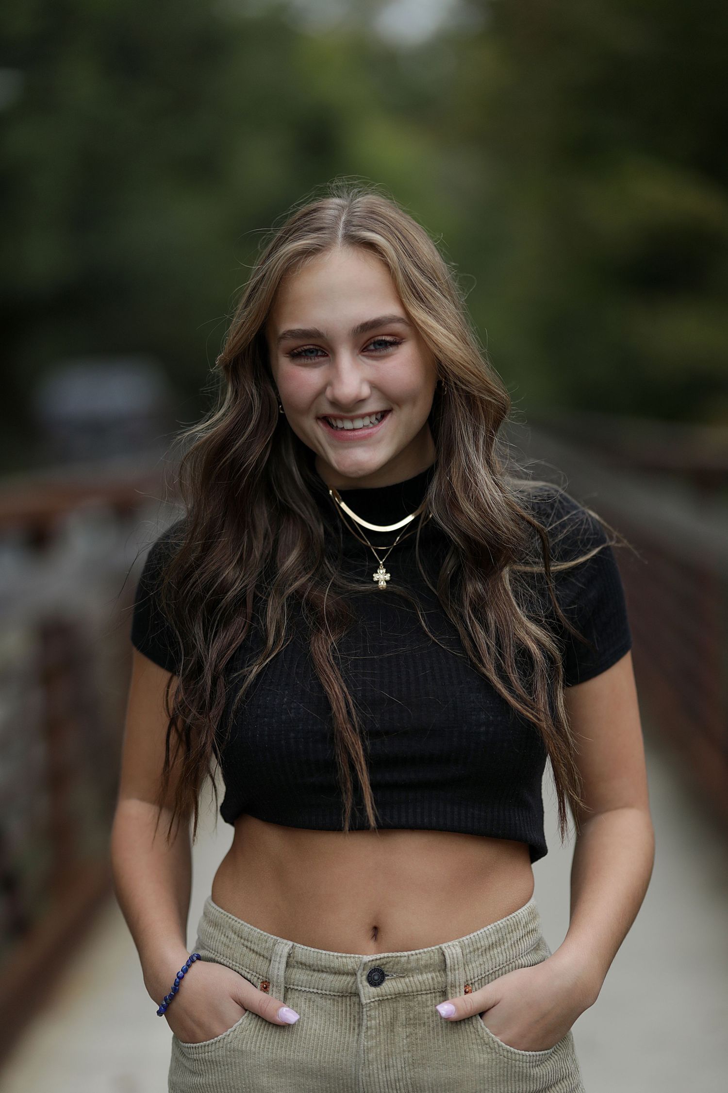 Portrait session on a wooden bridge pathway featuring casual attire and natural lighting.