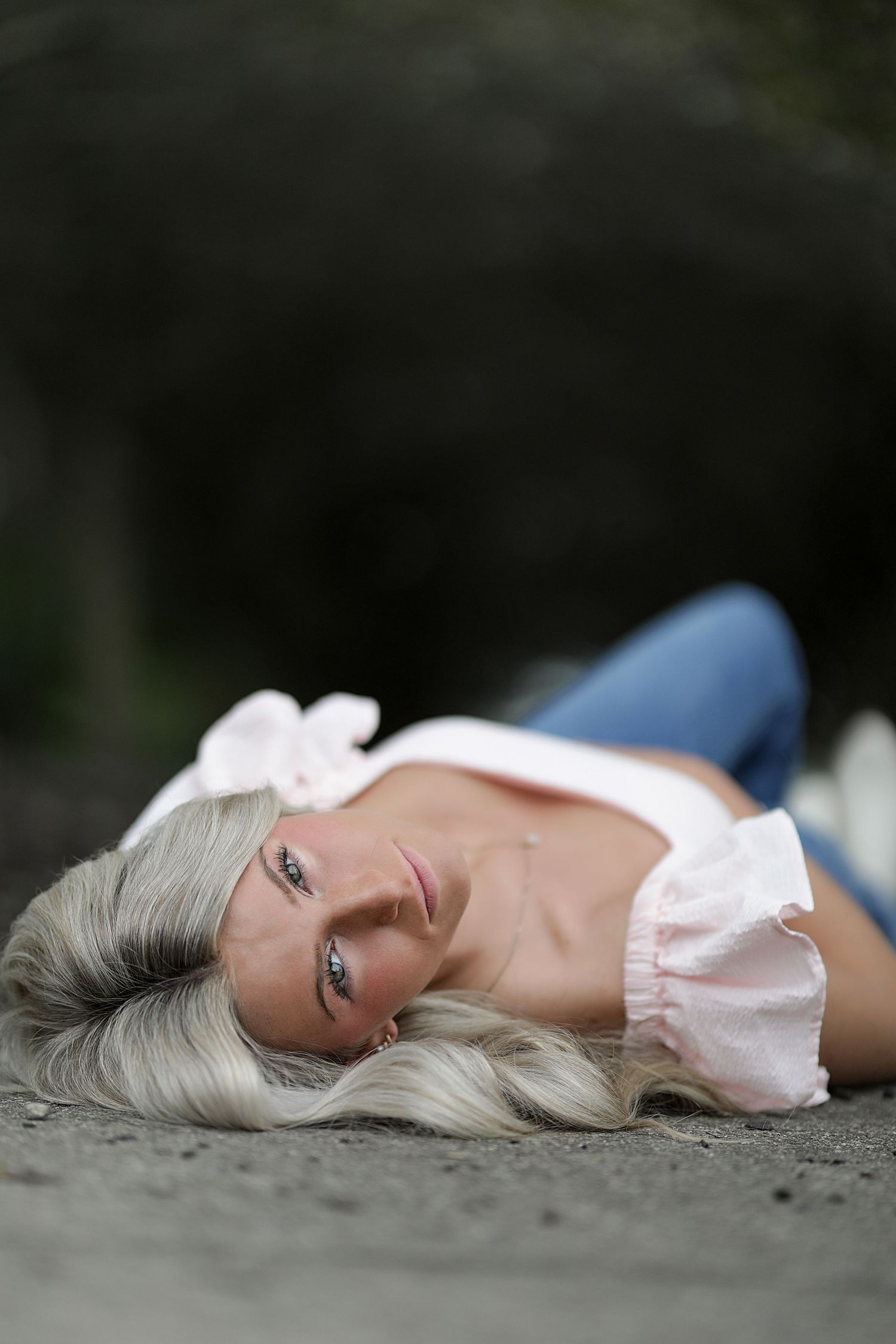 A person with flowing platinum blonde hair lies serenely on the ground in varying dramatic poses.
