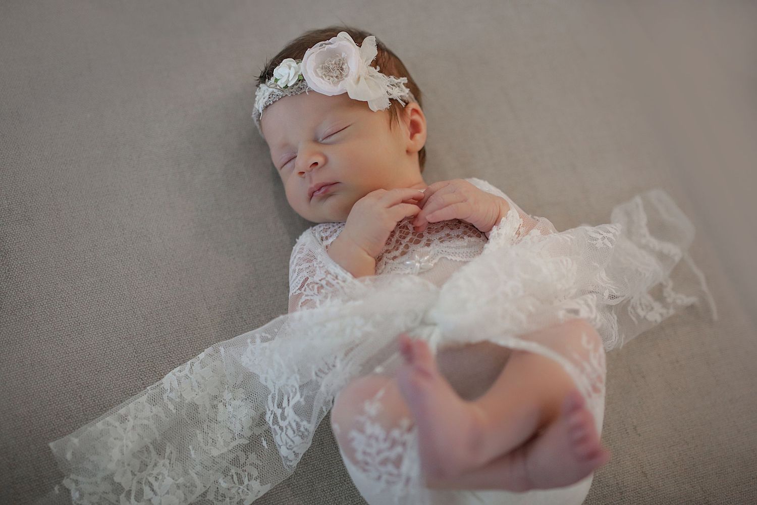 An artful monochrome series captures a newborn baby photo session with delicate lace wraps and soft lighting.