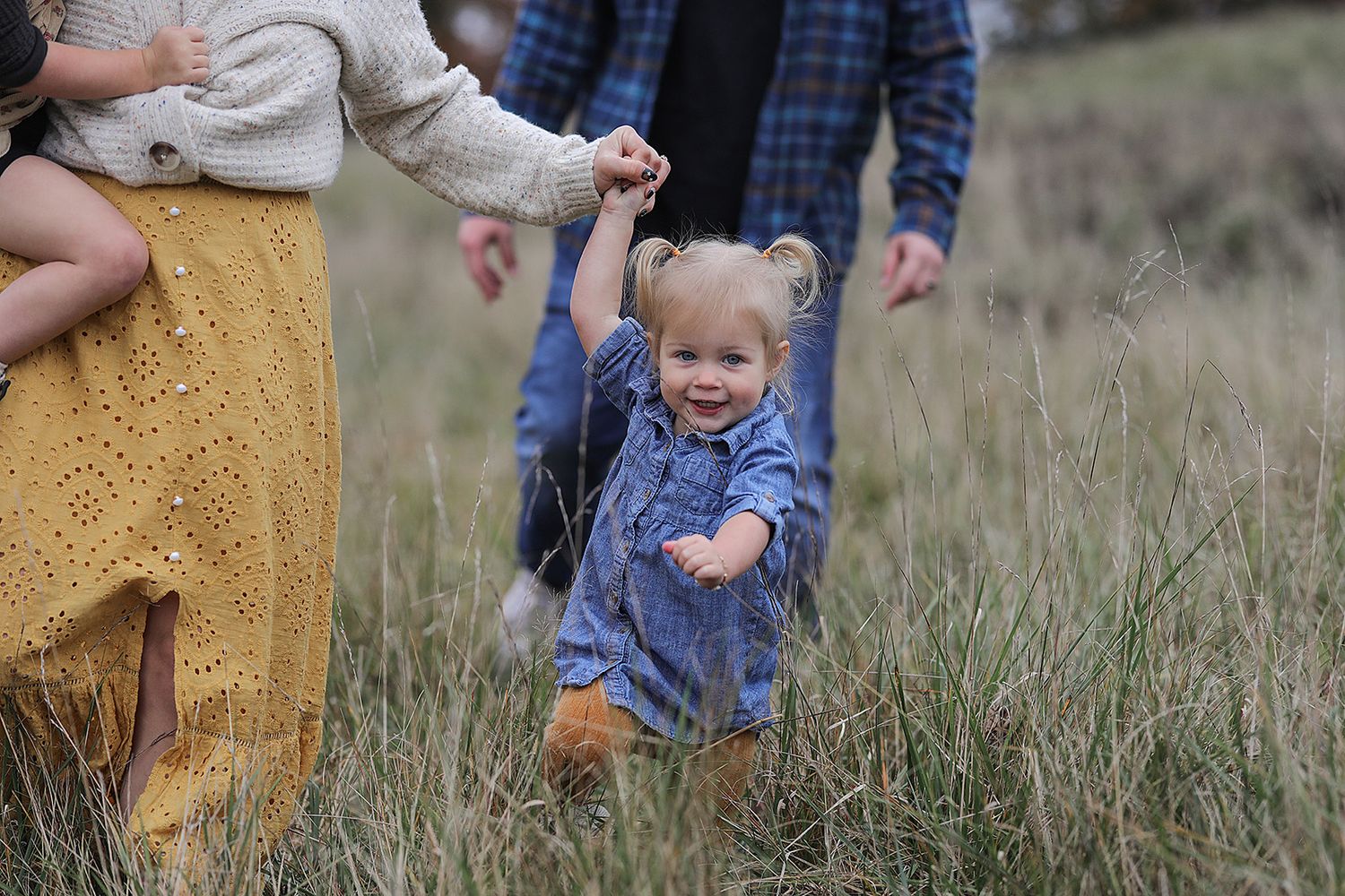 Casual family moments captured in outdoor field with natural styling.