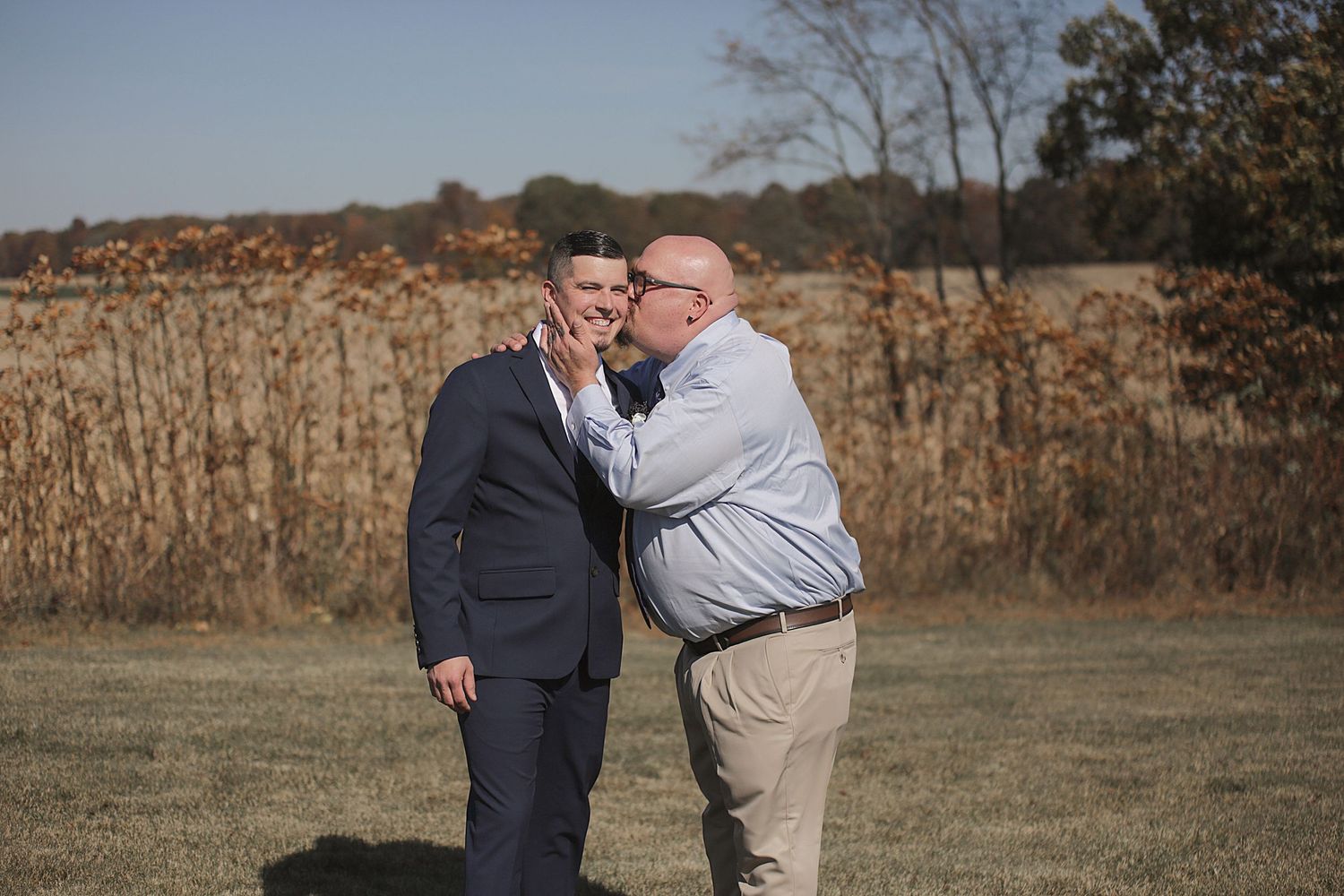 An emotional moment captured between two people in a field during autumn.