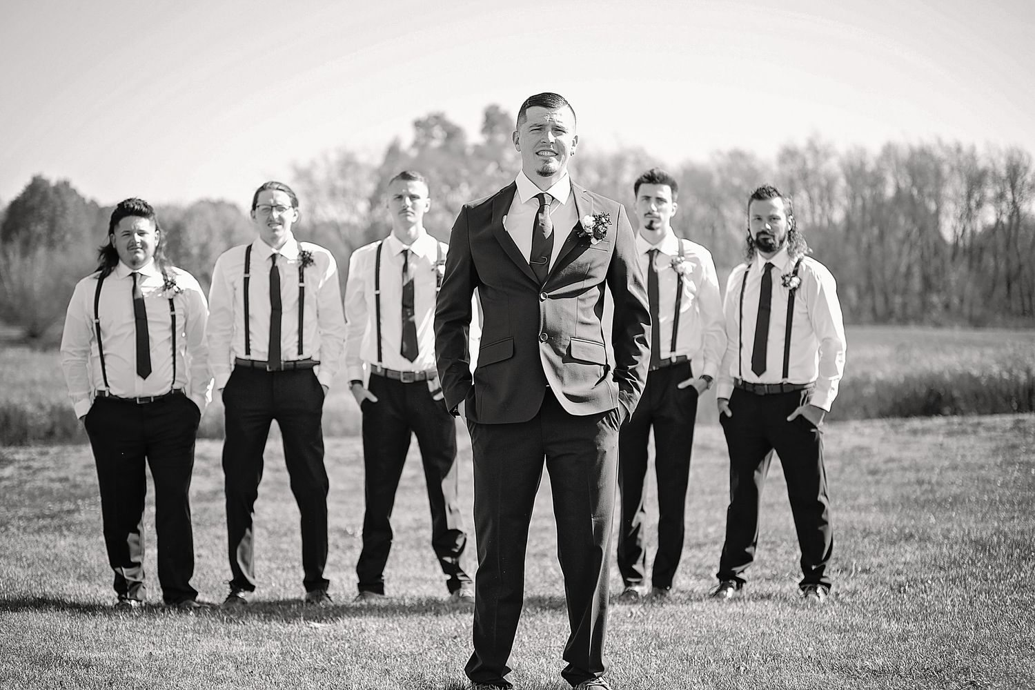Wedding party walking together outdoors in black and white photo.