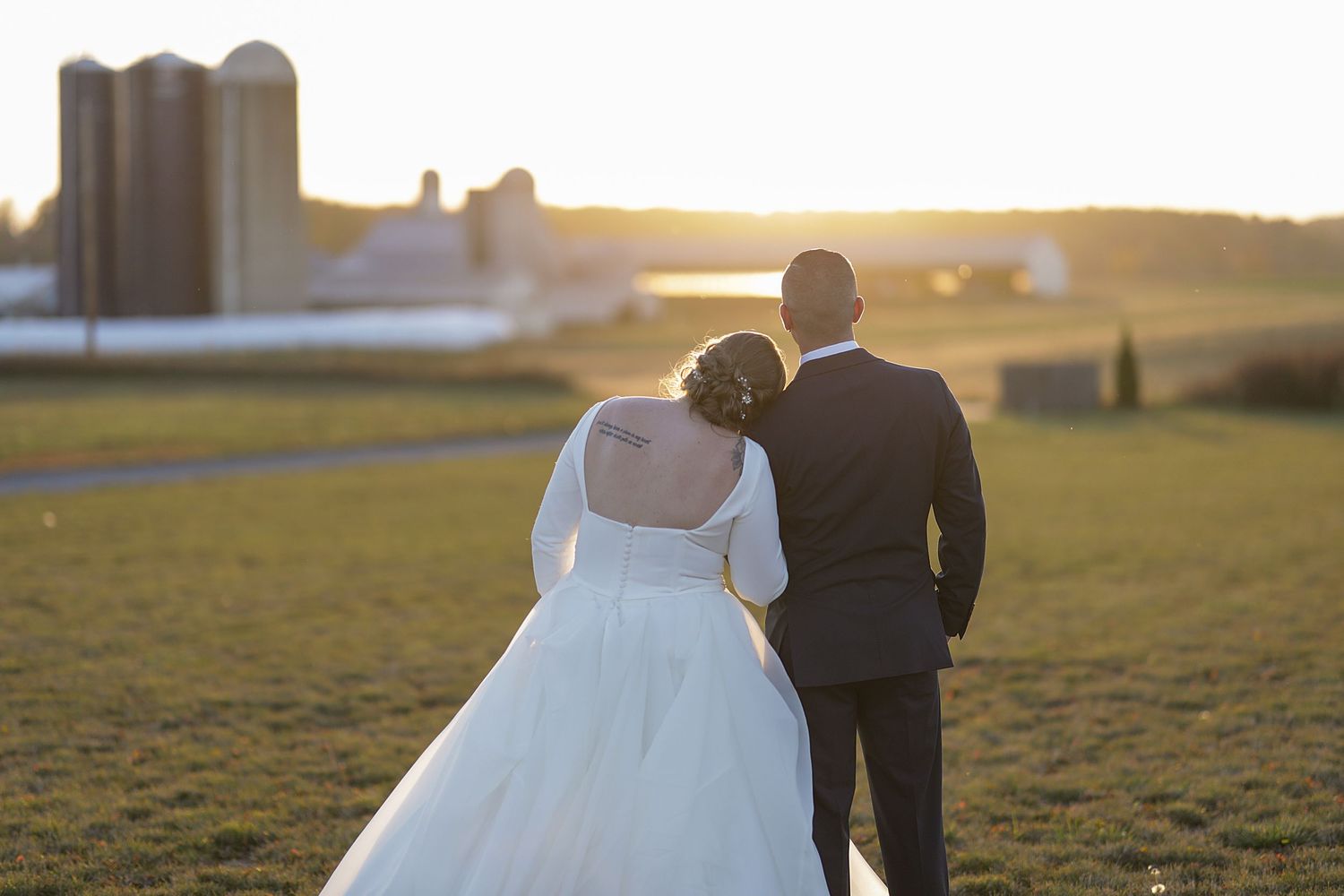 Romantic sunset wedding photos captured in a golden-lit field.