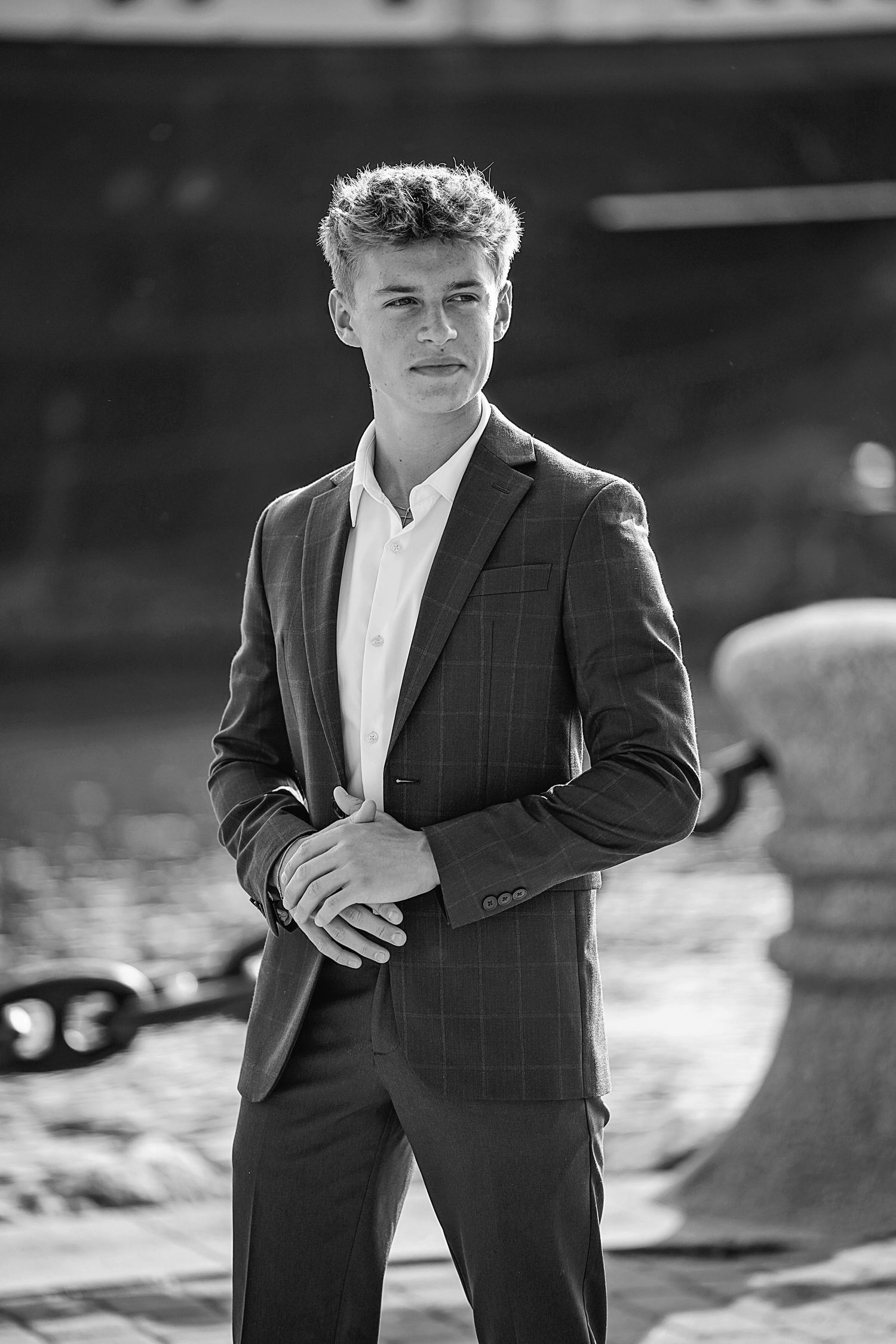 High school senior. Professional headshot of young man in plaid suit against blurred outdoor background. Senior portraits Strongsville, Ohio
