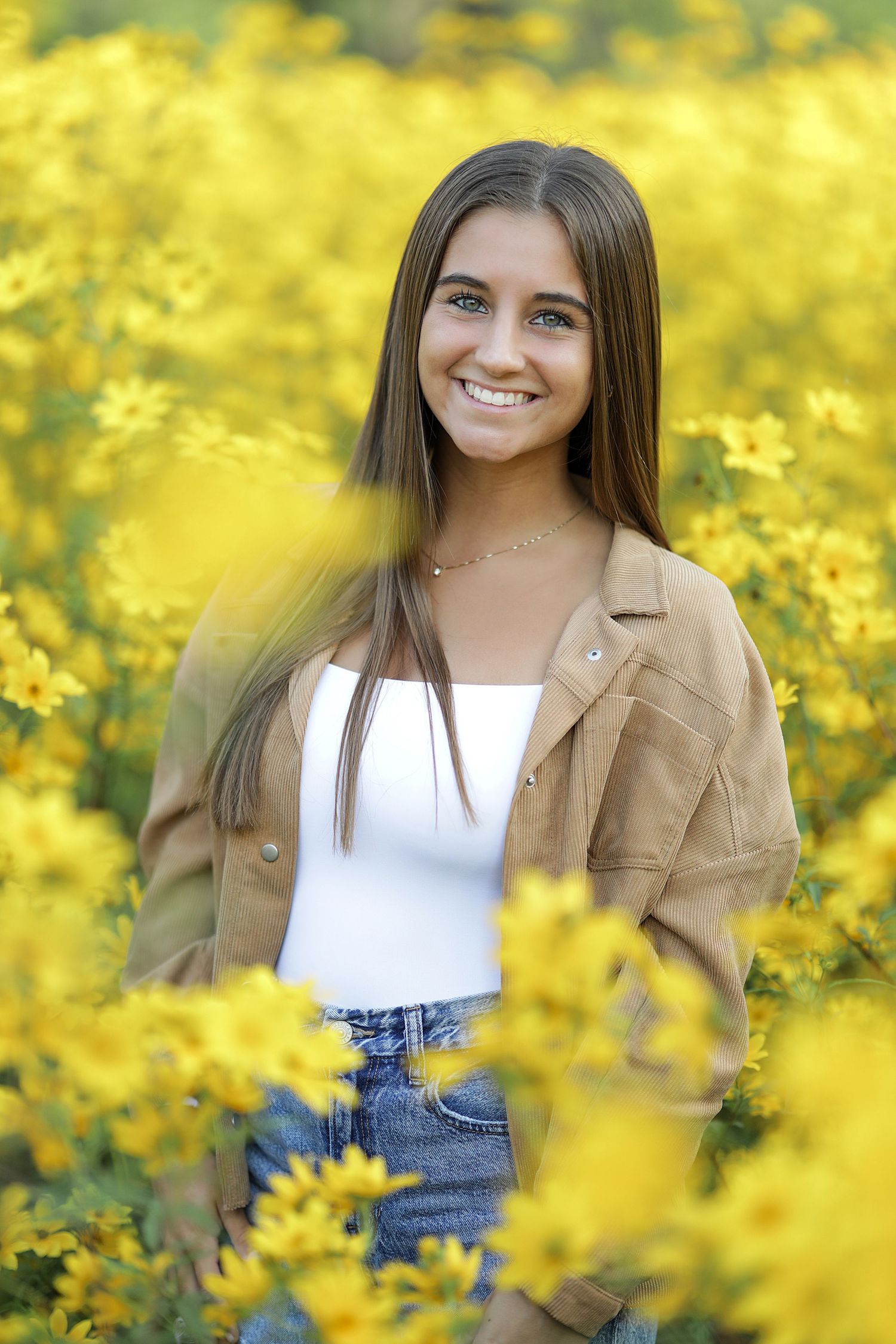 Portrait photo series in a vibrant yellow wildflower field showing poses in a white top and tan jacket.