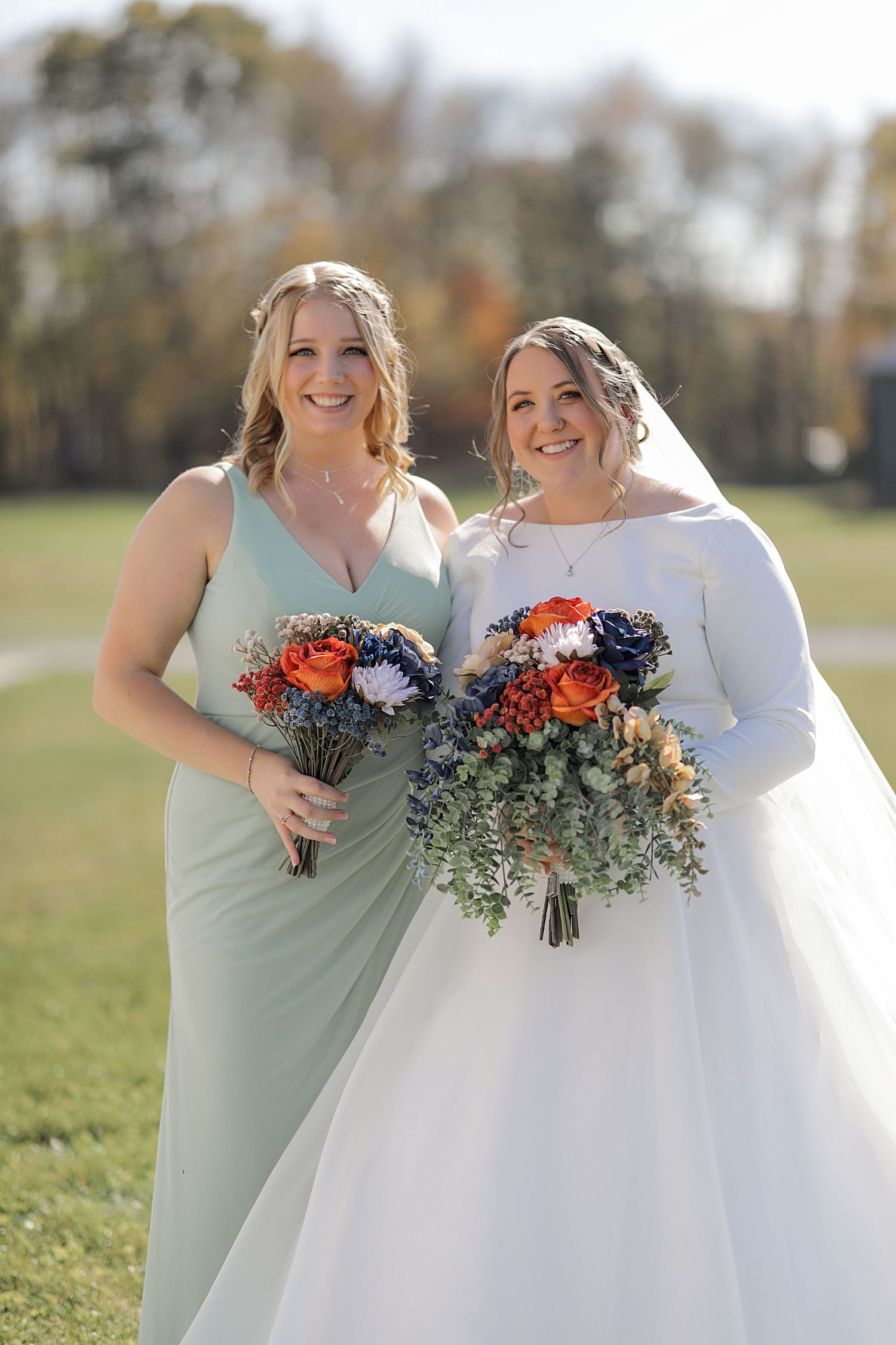 Beautiful wedding bouquets with orange and blue flowers against a mint green bridesmaid dress.