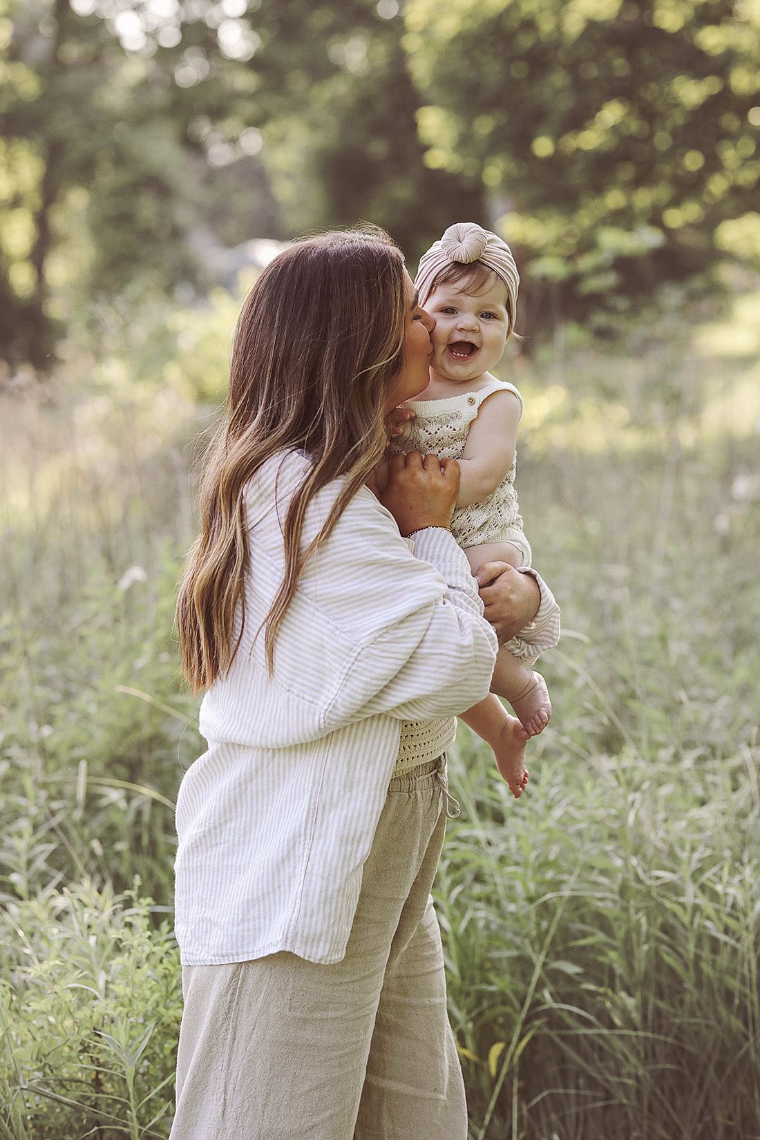 Sweet candid moments between parent and child in white outfits outdoors.