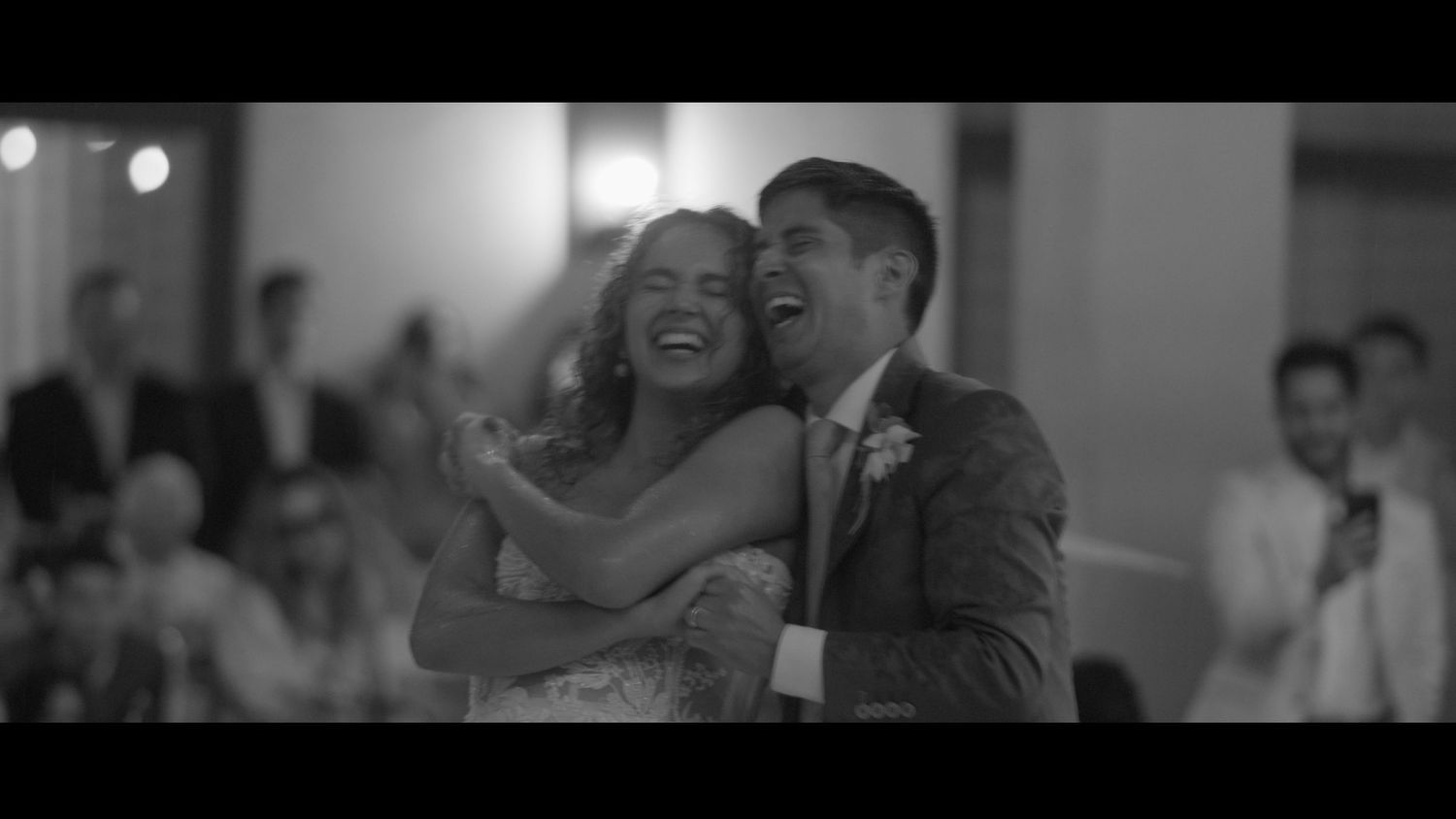 A candid black and white reception photo of a dancing couple.
