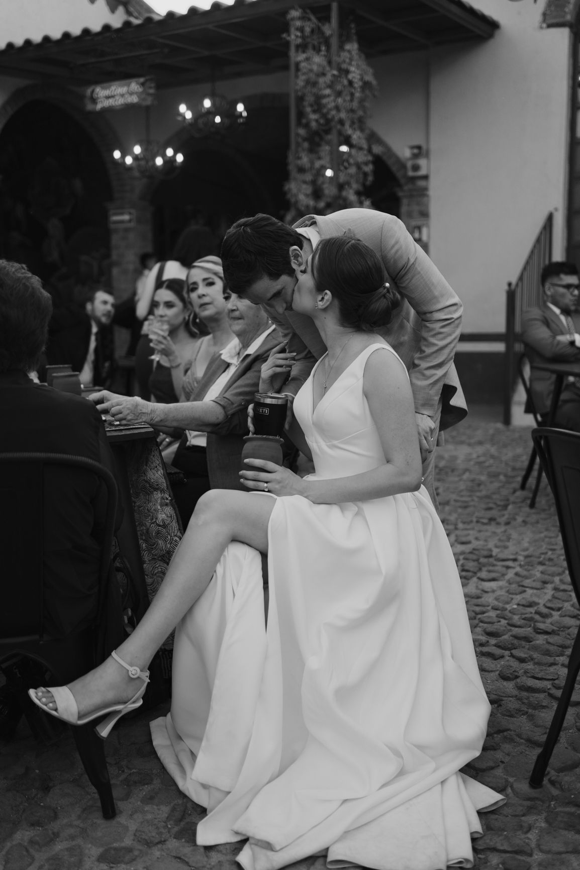 Wedding reception scene at a rustic outdoor venue with cobblestone flooring.