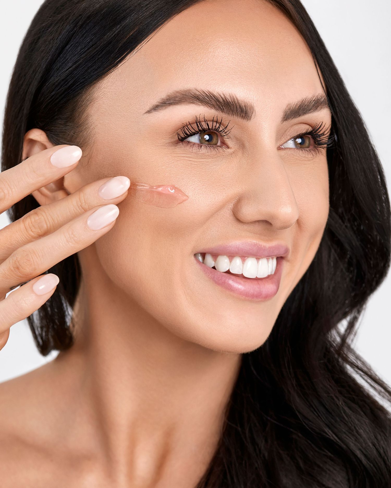 Beauty shot demonstrating skincare product application on cheek.