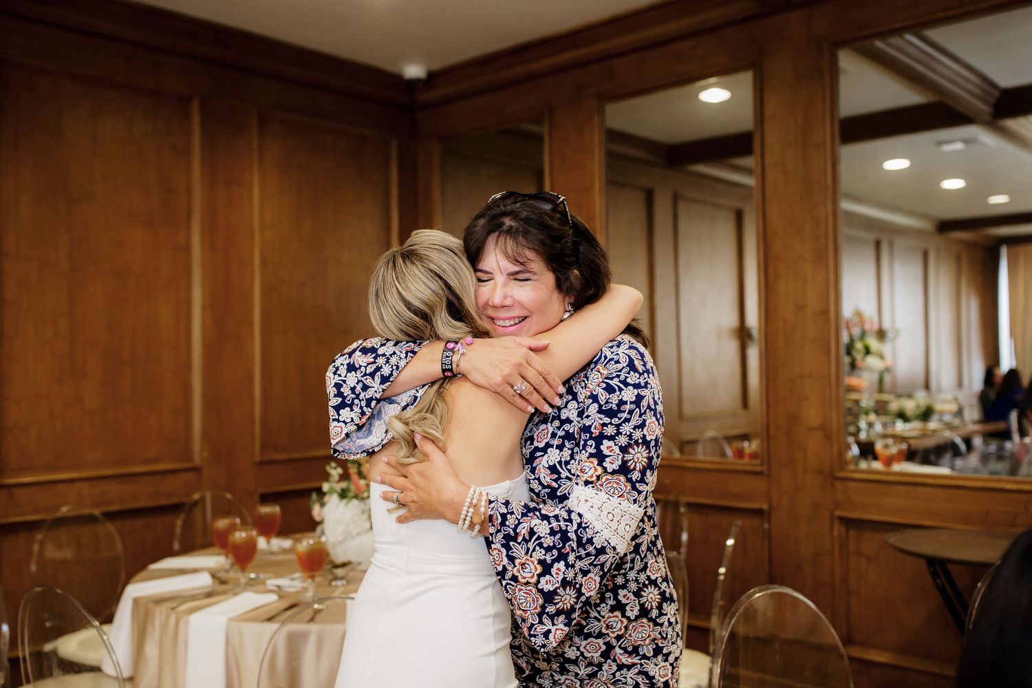 Group sharing emotional embraces and hugs at an indoor celebration event.