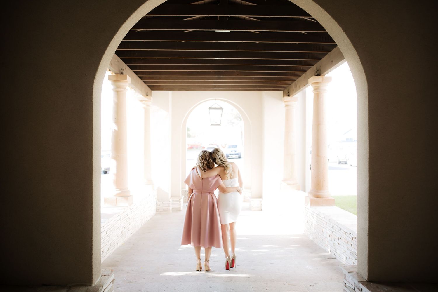 A light-filled archway corridor creates a romantic silhouette of a couple walking together.