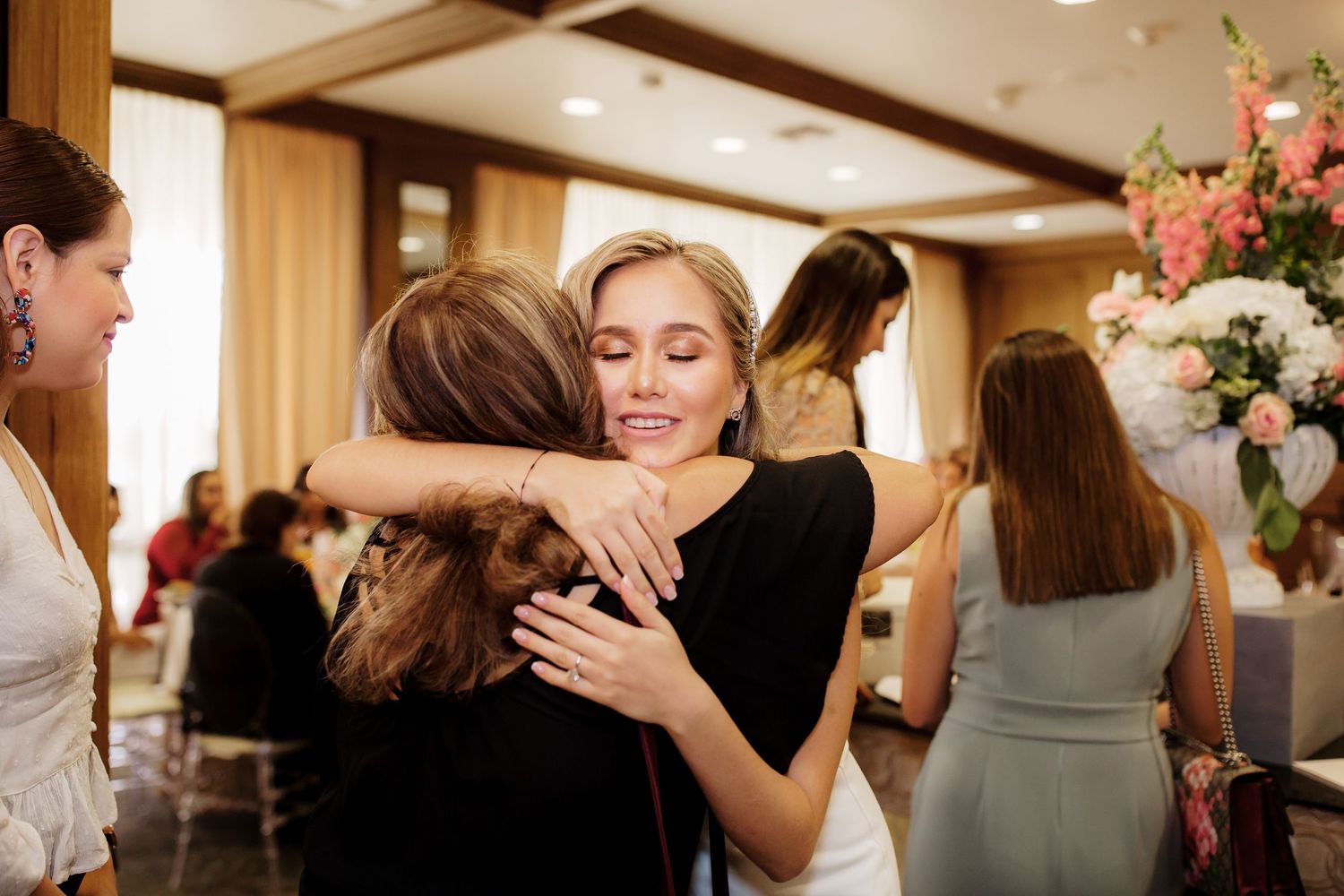 Wedding guests sharing emotional embraces and moments during a reception celebration.