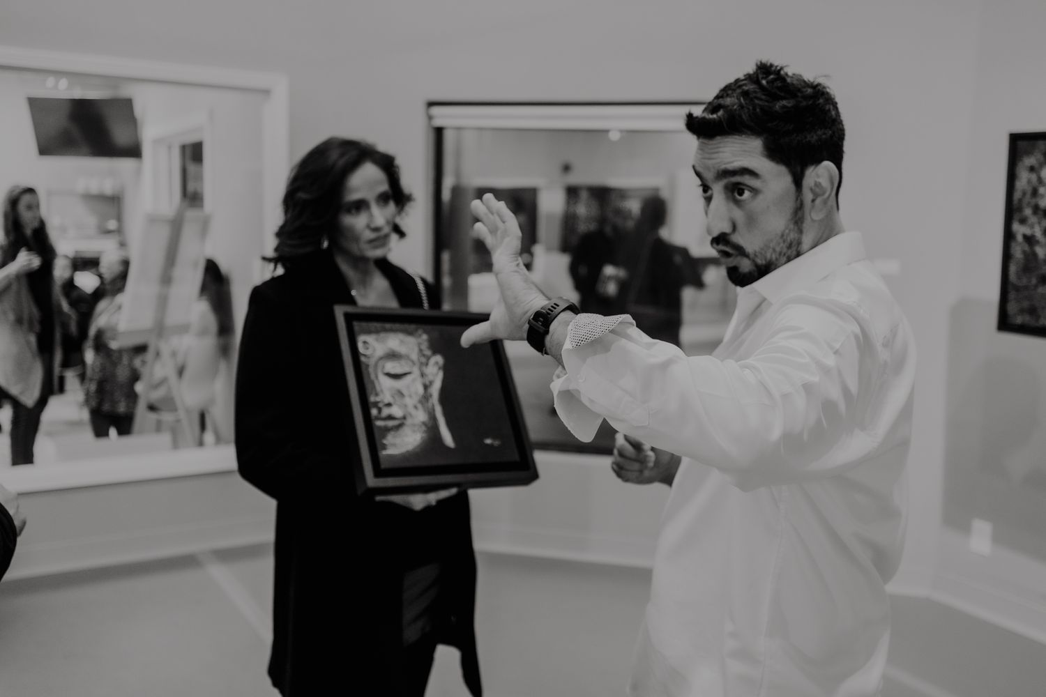 A professional photographer adjusts camera settings while capturing a fashion photoshoot in a studio setting.