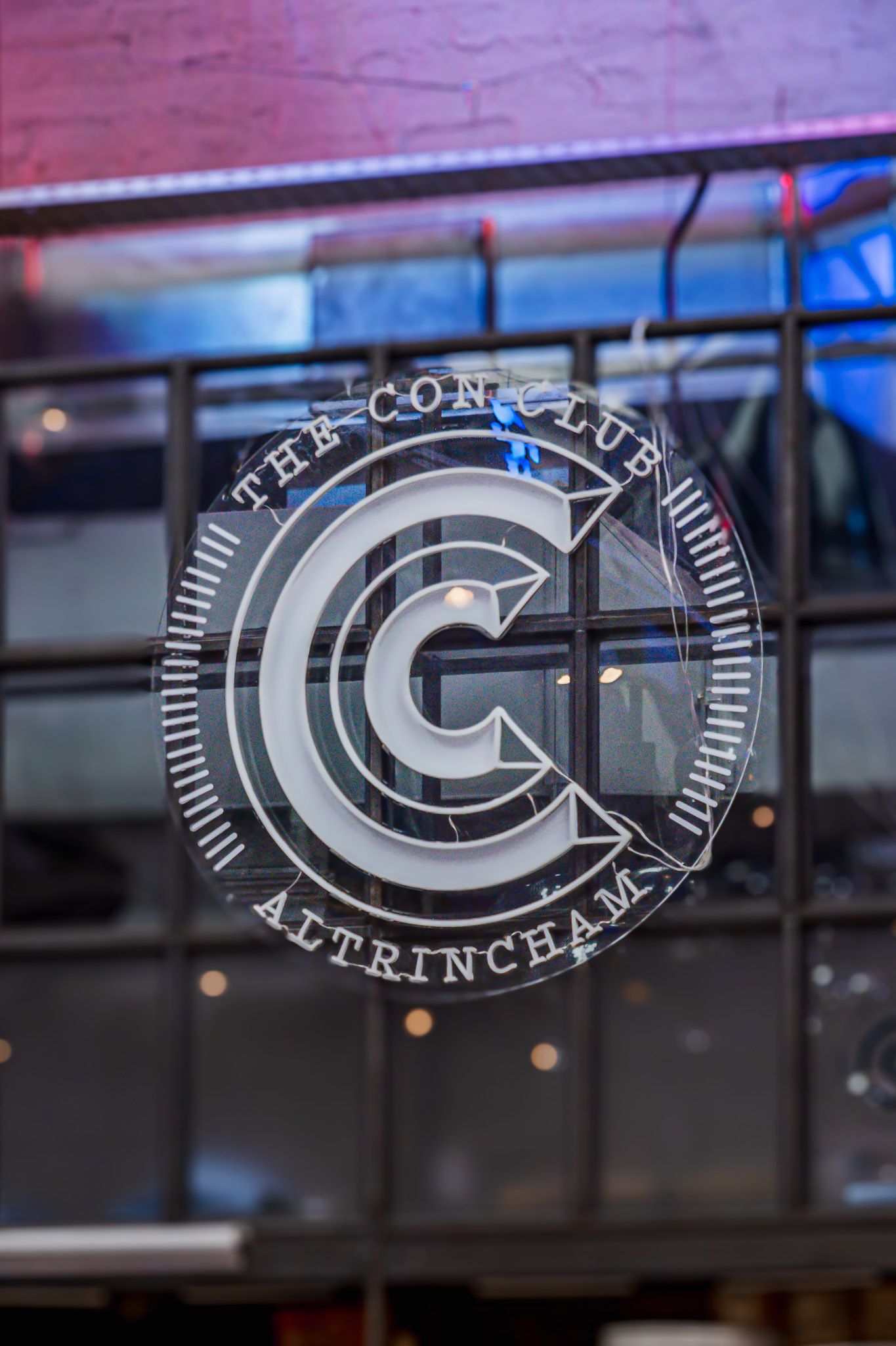 Circular logo design with letter G on glass window.