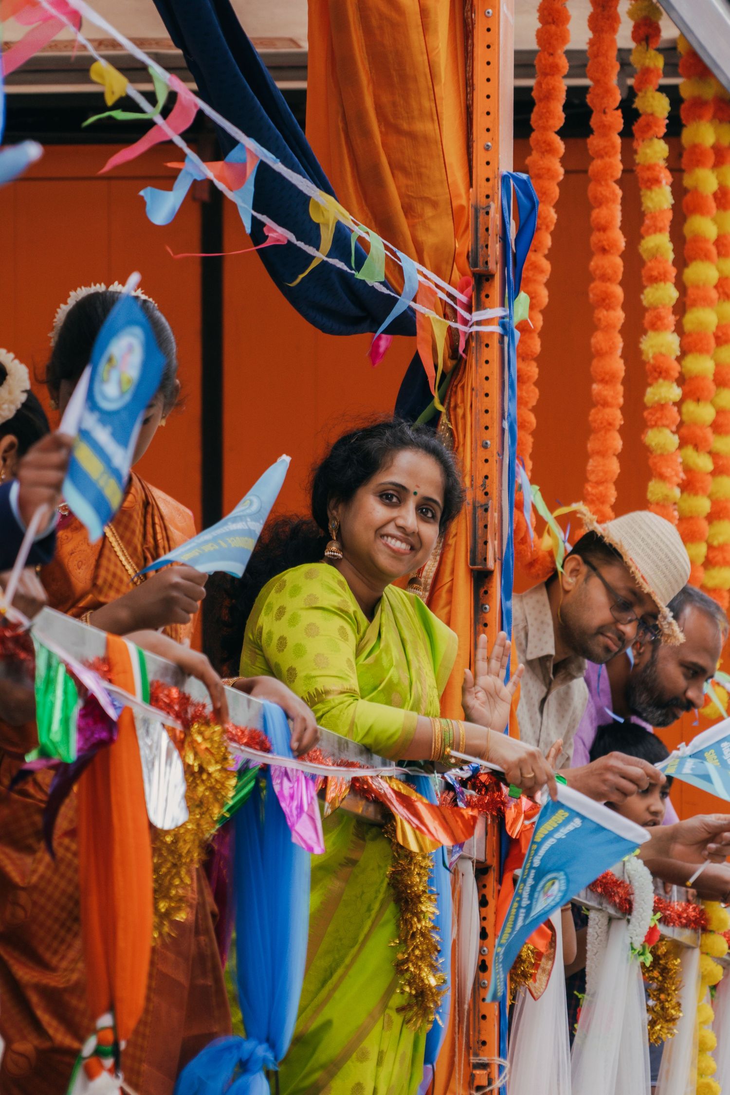 A festive scene with colorful bunting and orange marigold decorations during what appears to be an Indian celebration.