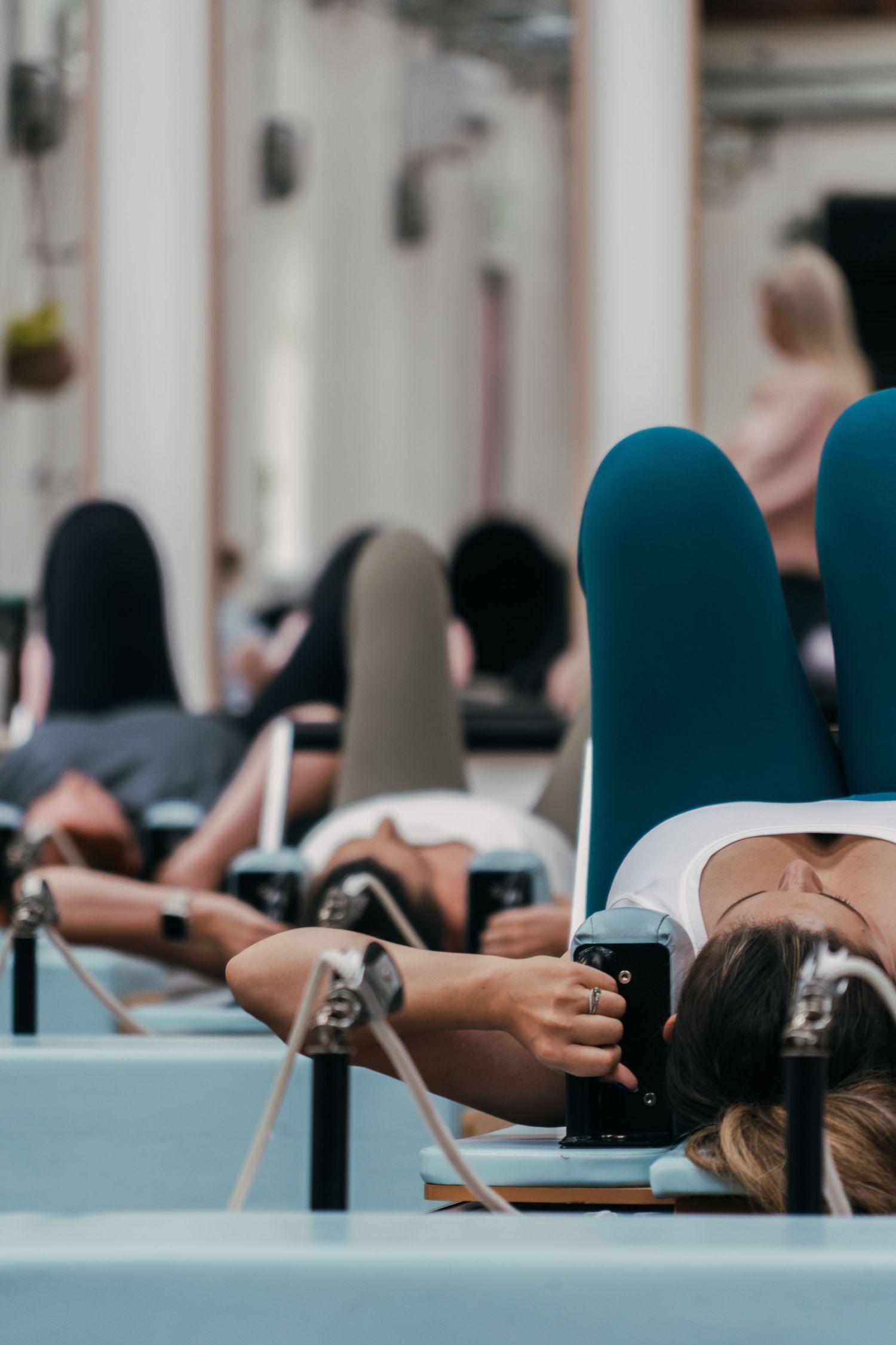 People lying on light blue floor mats during a group fitness class focusing on core exercises and stretching.
