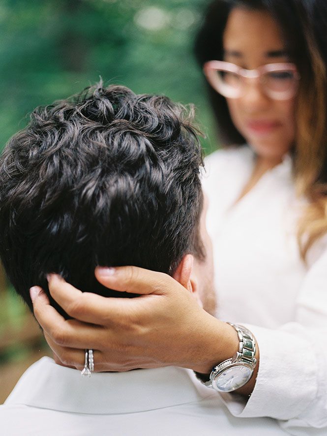 A sequence of intimate close-up shots showing hands cradling a head against a blurred green background.
