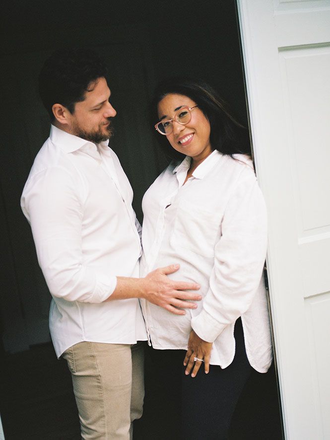 A couple wearing white shirts shares an intimate moment together near a doorway.