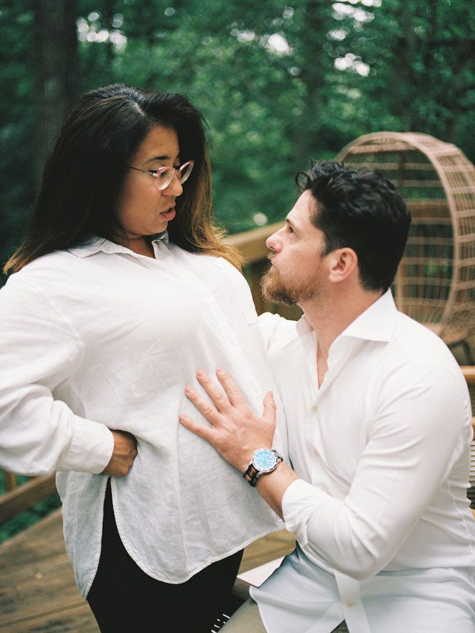 A romantic sequence of a couple in white clothing embracing outdoors with natural greenery in the background.
