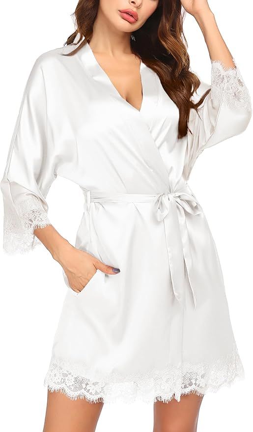 White satin robe with lace trim and waist tie belt features flowing three-quarter length sleeves and side pockets.