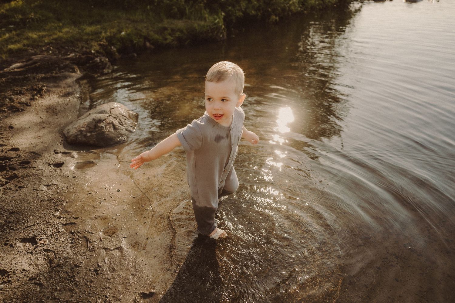A series of photos showing someone splashing and playing in the shallow waters of a lake during golden hour light.