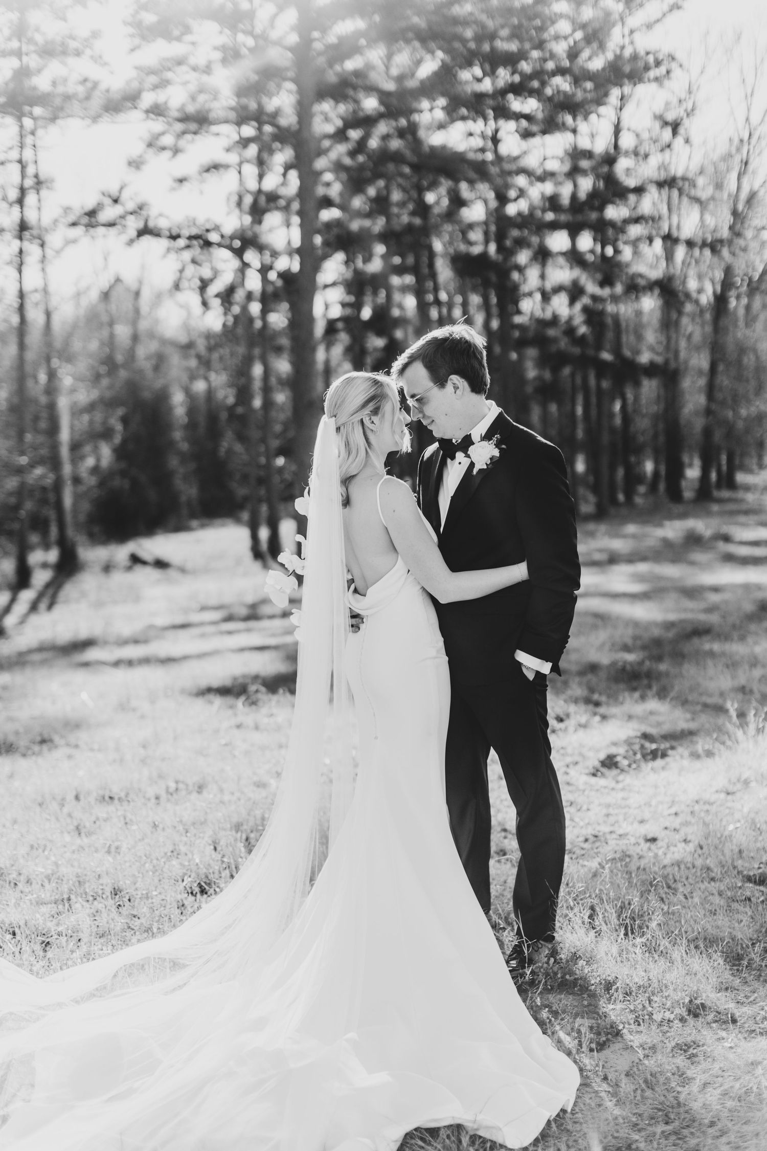 Black and white wedding portraits in a serene wooded setting.