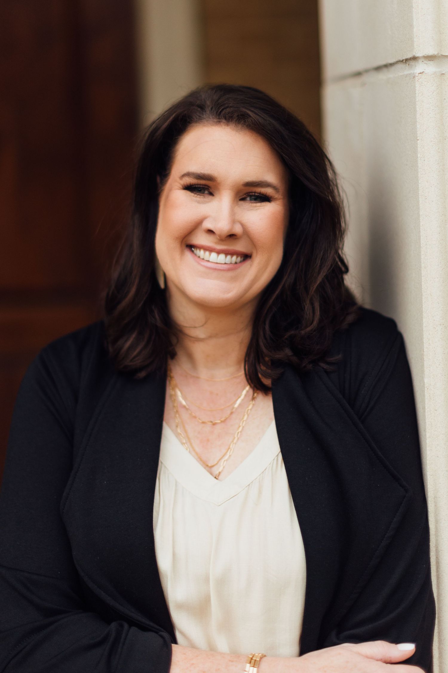 Professional portrait series showing a person in a black blazer and white top smiling warmly against a blurred background.
