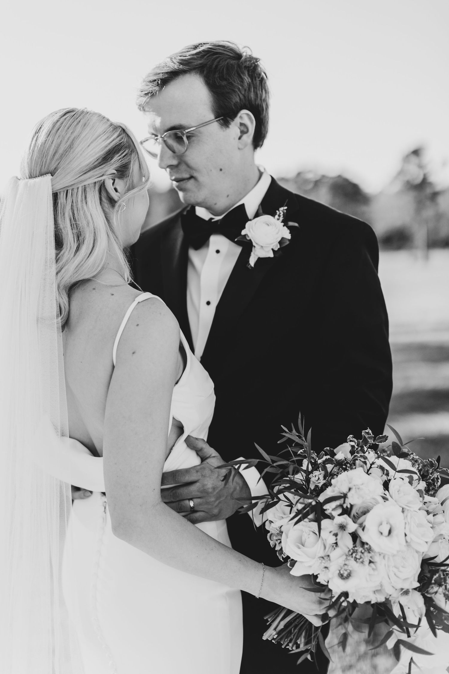Black and white wedding portraits capture tender moments between newlyweds.
