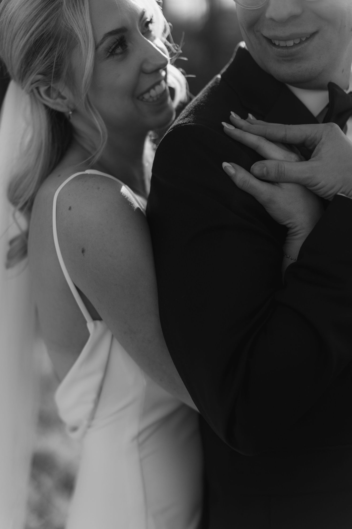 Intimate black and white portrait captures tender wedding moment between couple.