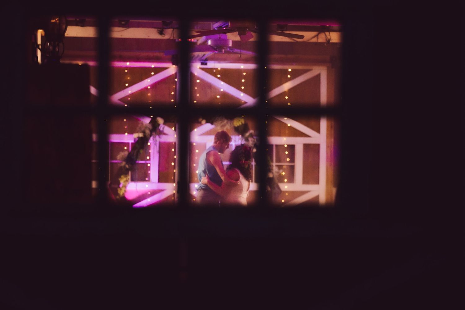 a couple dancing with a window frame in foreground