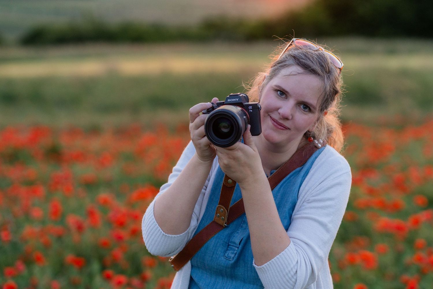 über mich - Fotografin mit Kamera auf einem Mohnfeld bei Sonnenuntergang in Stockerau Wien bei Familienfotoshooting Outdoor