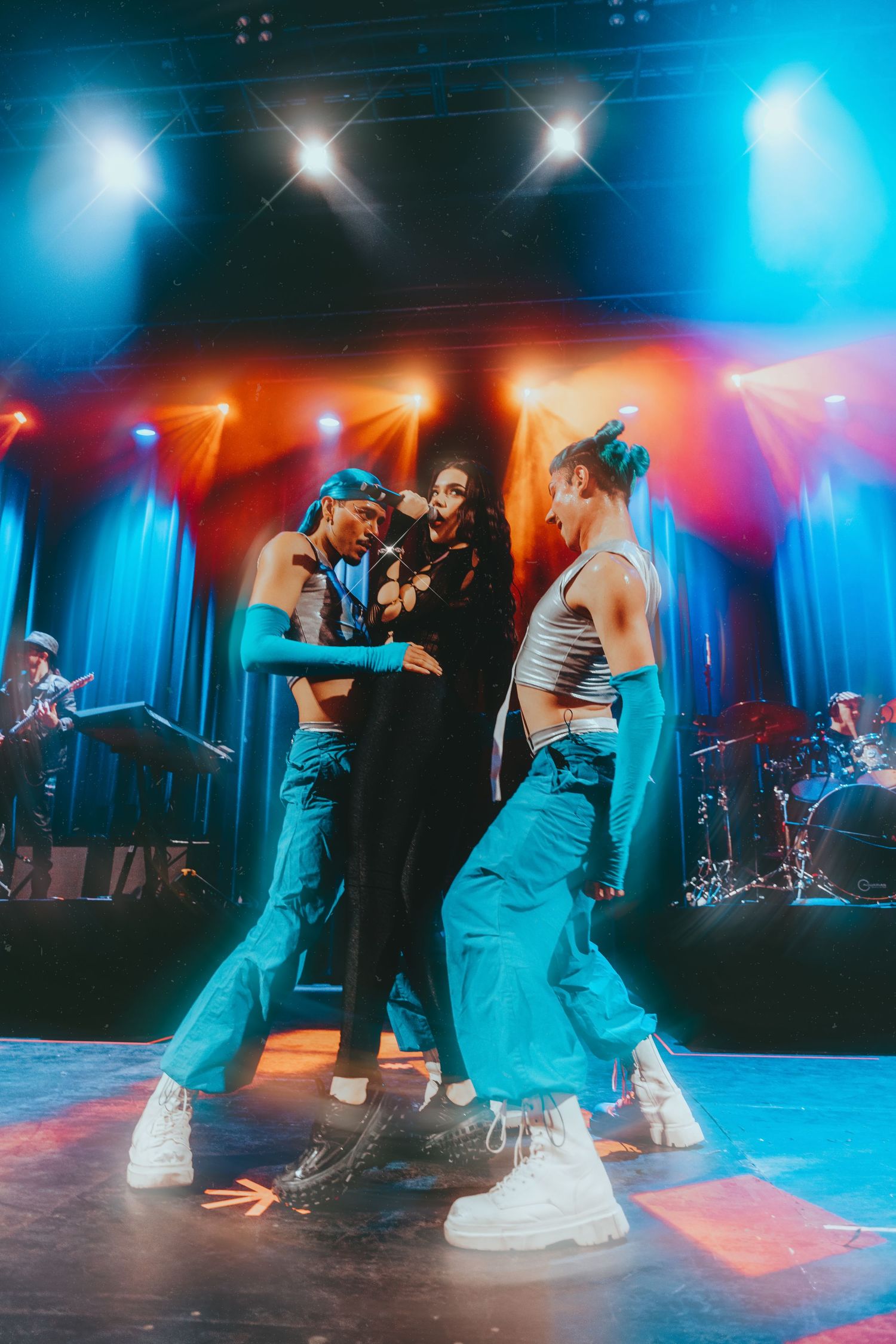 Kenia-os music artist sining at a concert with backup dancers