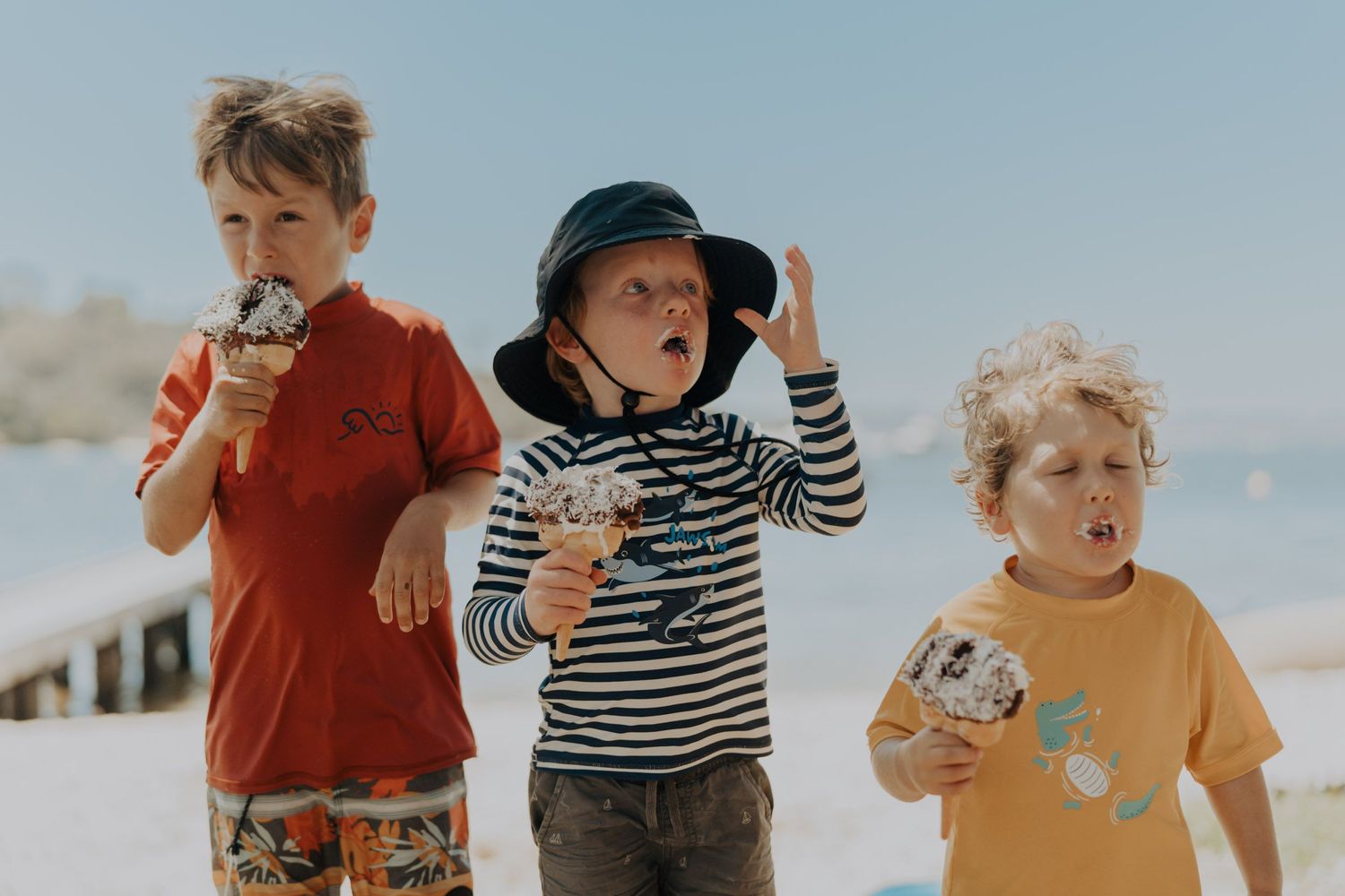 Three children eating icecream at the beach