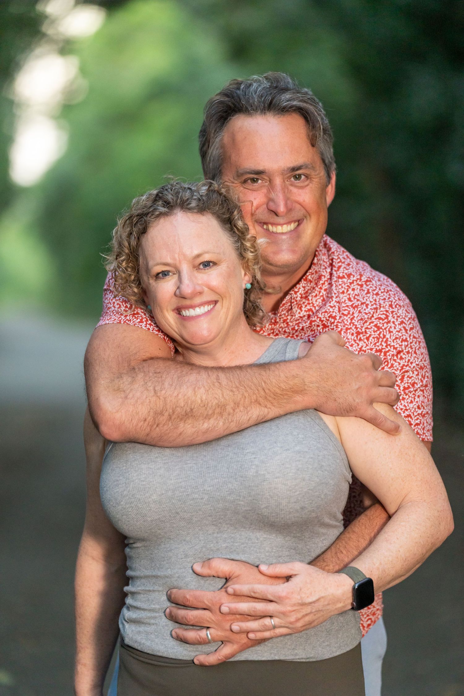 Couple embracing and showing affection outdoors during a casual photo shoot.