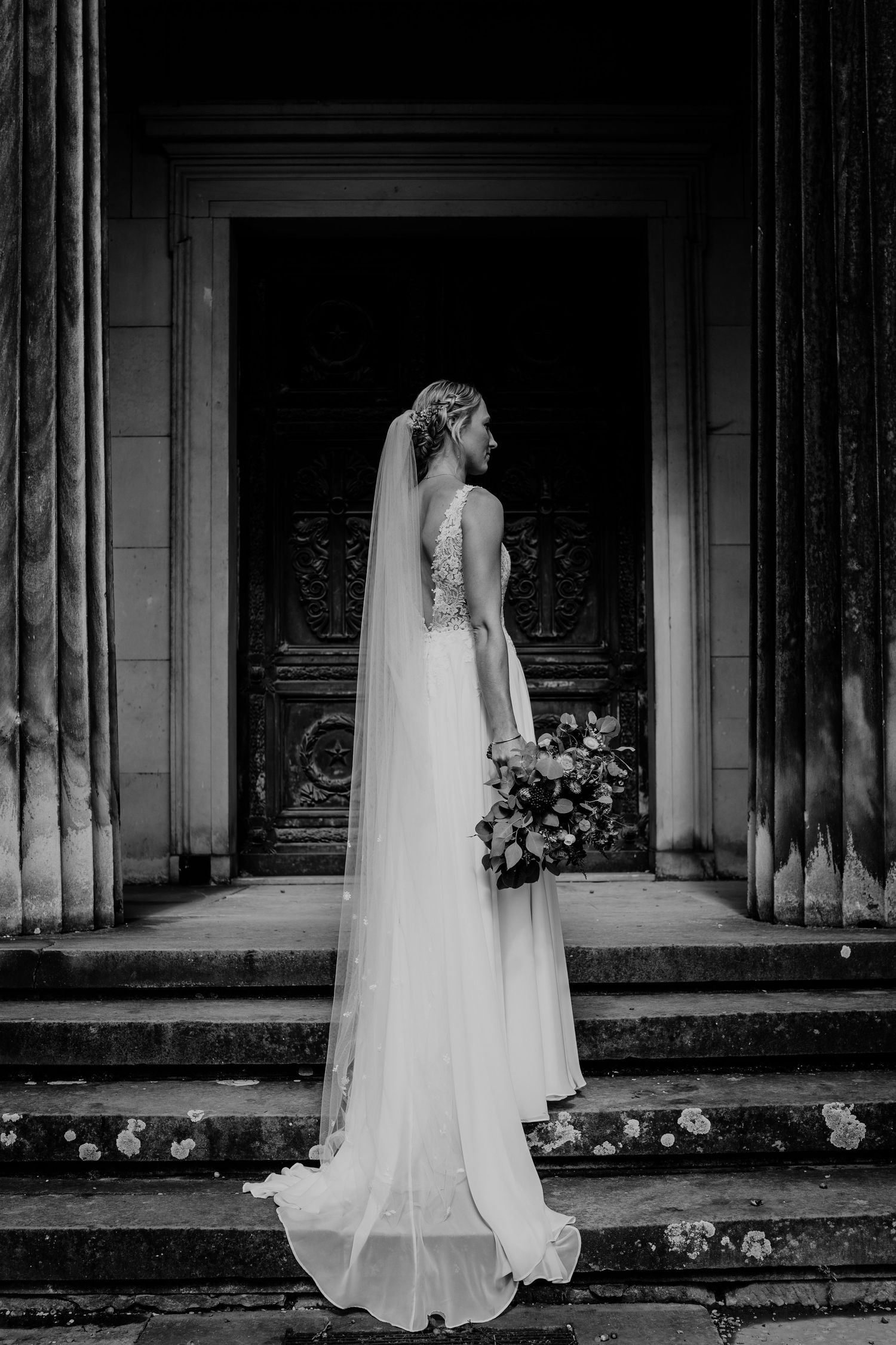 Hochzeit in den Herrenhäuser Gärten. Braut steht im wunderschönen Kleid auf einer Treppe.