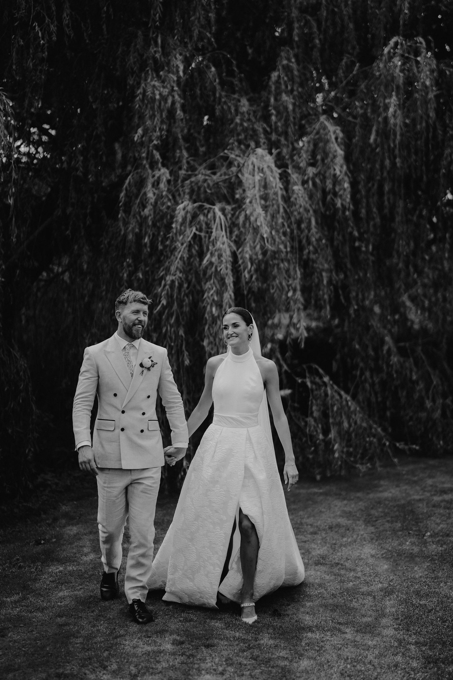 bride and groom walking under willow tree in islip, oxfordshire