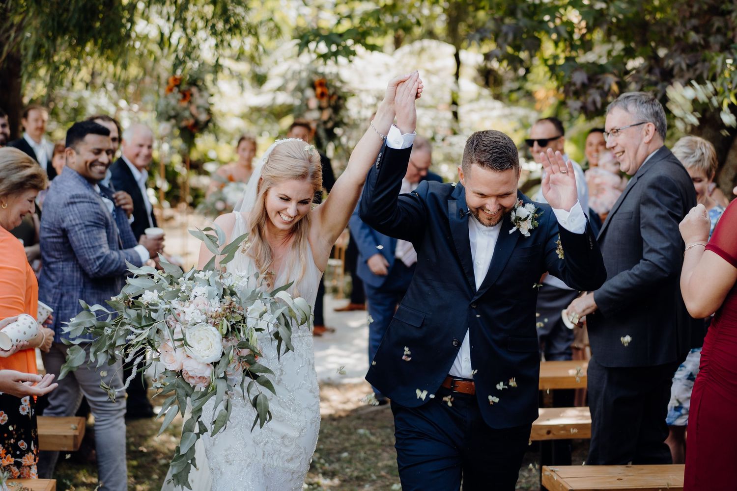 Bride and groom celebrating as they down the aisle