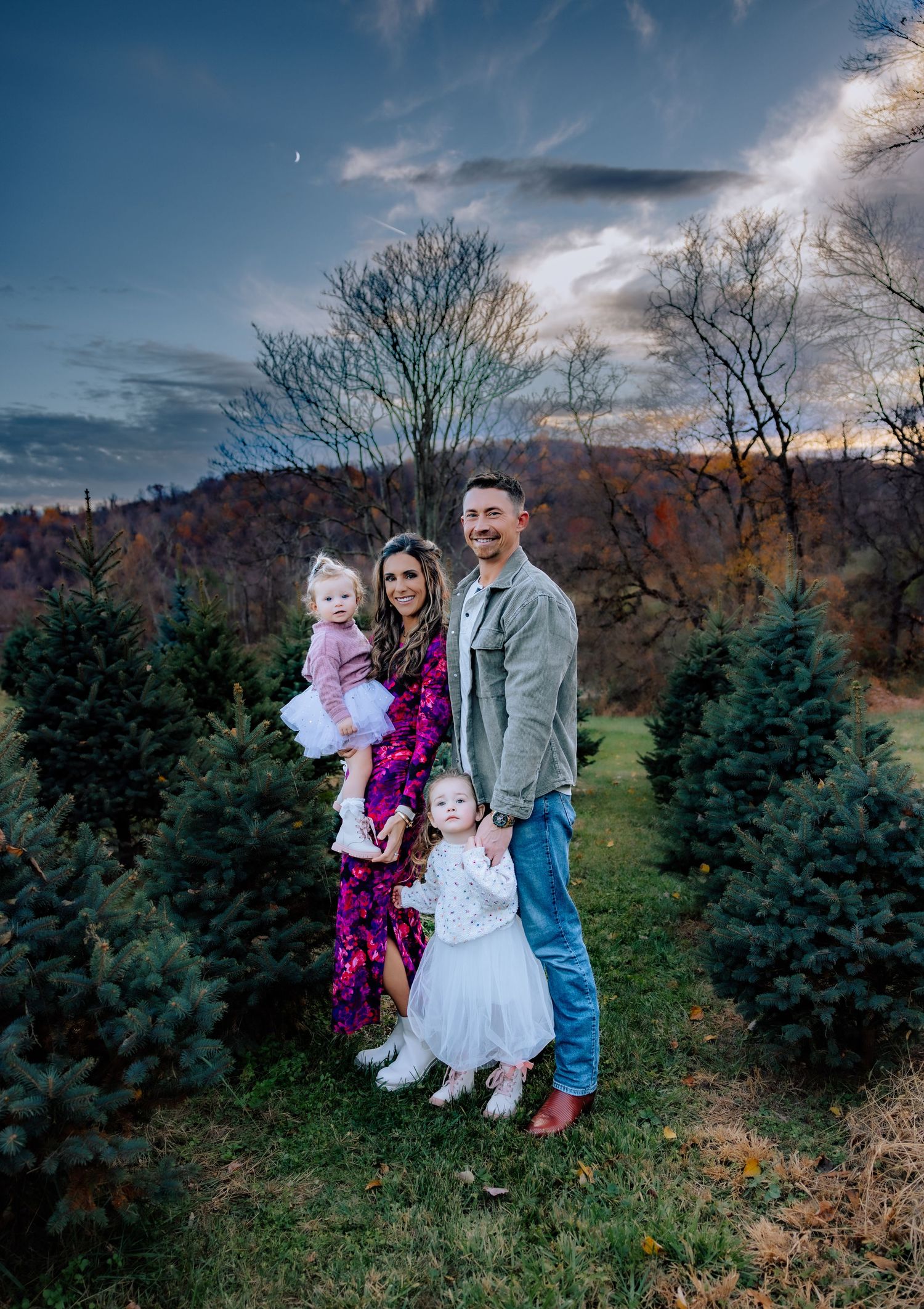 Family photos at a Christmas tree farm during sunset with evergreens in the background.